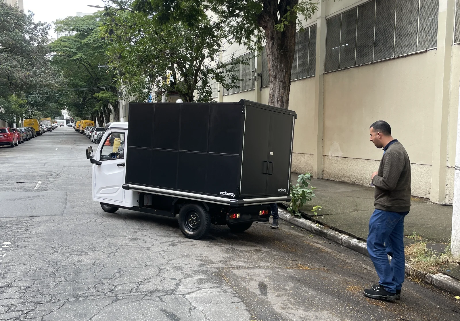 Clique para editar a descrição da imagem Triciclo elétrico Besouro Delivery Cicloway durante trajeto urbano de entregas de mercadorias.