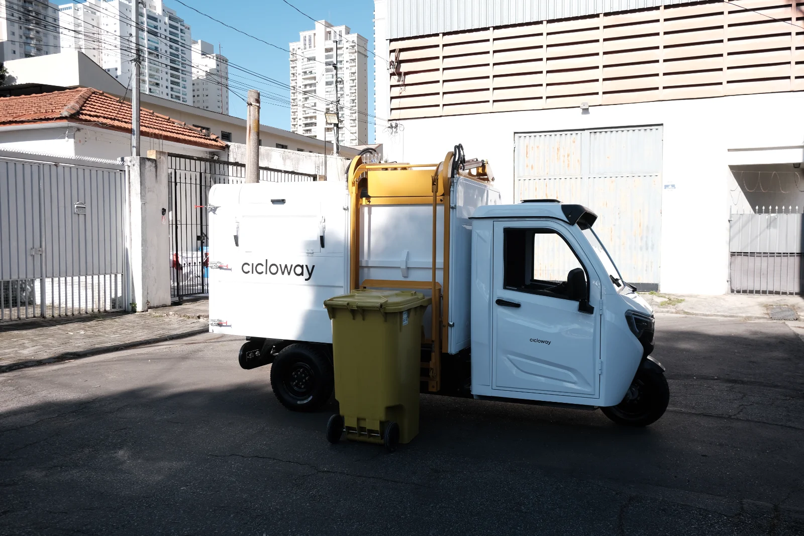 Triclo elétrico Besouro Eco L - elevação lateral do container com sistema automatizado de coleta.